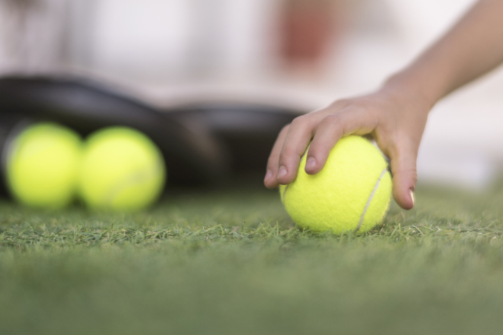 Paddle tennis rackets and ball on turf